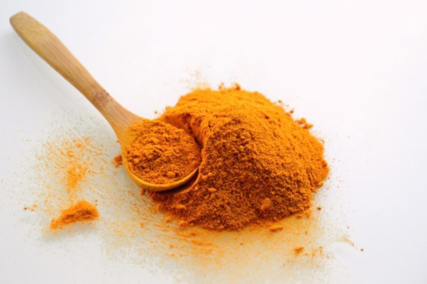 Bright yellow curry powder in a small bowl, ready to use as a spice.