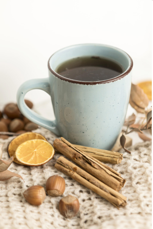 Une tasse de thé à la cannelle entourée de bâtons de cannelle