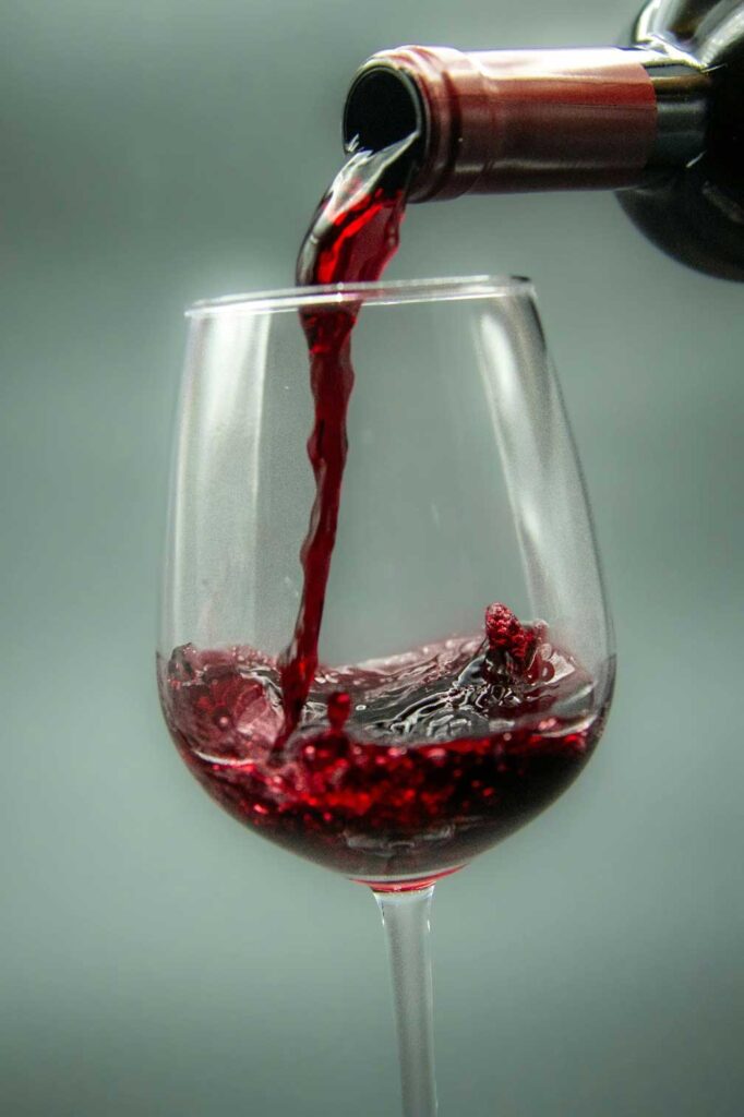 Glass of red wine with deep ruby color, served in a clear wine glass.