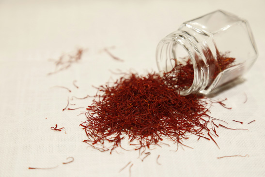 Fresh saffron threads stored in a jar, showcasing the vibrant color and aroma of the precious golden spice.